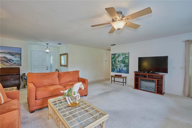 living room featuring ceiling fan, light colored carpet, and a textured ceiling