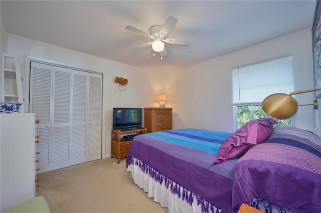 carpeted bedroom with ceiling fan and a closet