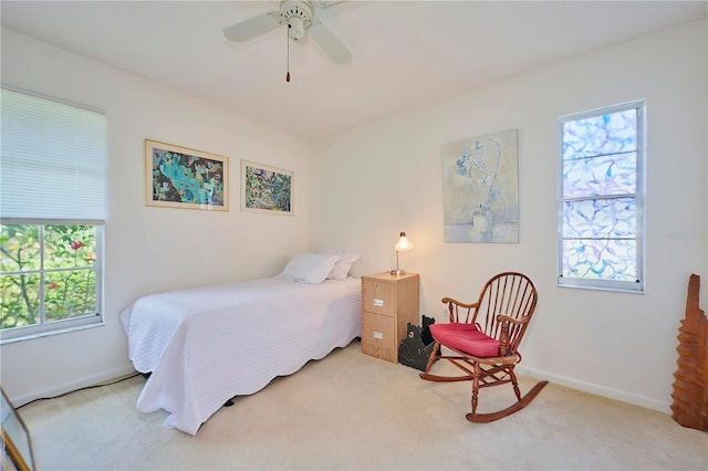 carpeted bedroom with ceiling fan and multiple windows