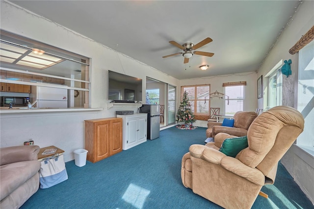 carpeted living room featuring ceiling fan