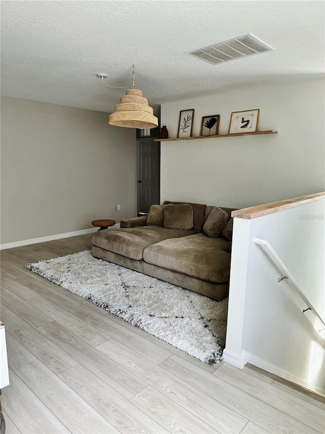 unfurnished living room featuring hardwood / wood-style floors and a textured ceiling