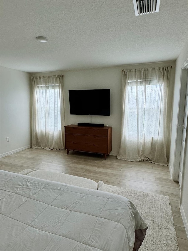 unfurnished bedroom with a textured ceiling and light hardwood / wood-style floors