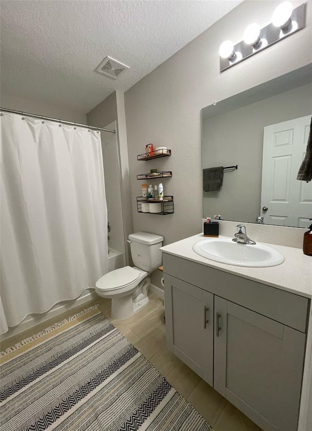 full bathroom with vanity, shower / tub combo, a textured ceiling, and toilet