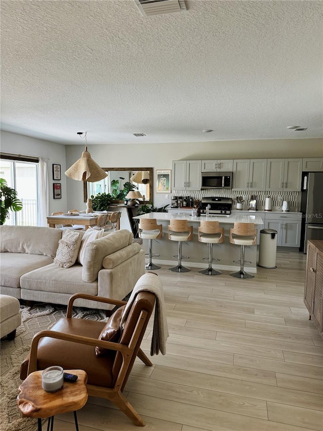 living room with light hardwood / wood-style flooring and a textured ceiling