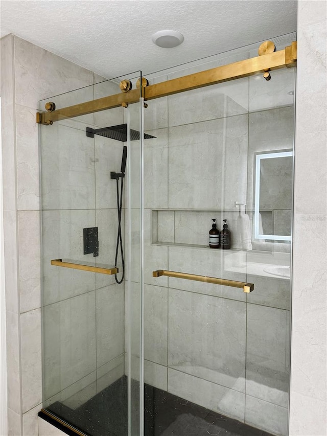 bathroom with a shower with door and a textured ceiling