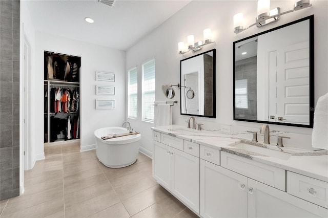 bathroom featuring a bathing tub, tile patterned floors, and vanity