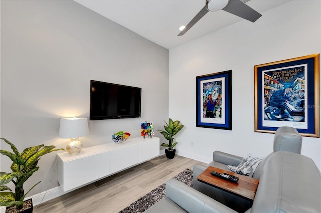 living room with ceiling fan and light hardwood / wood-style flooring