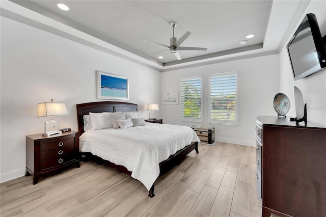 bedroom with ceiling fan and a tray ceiling