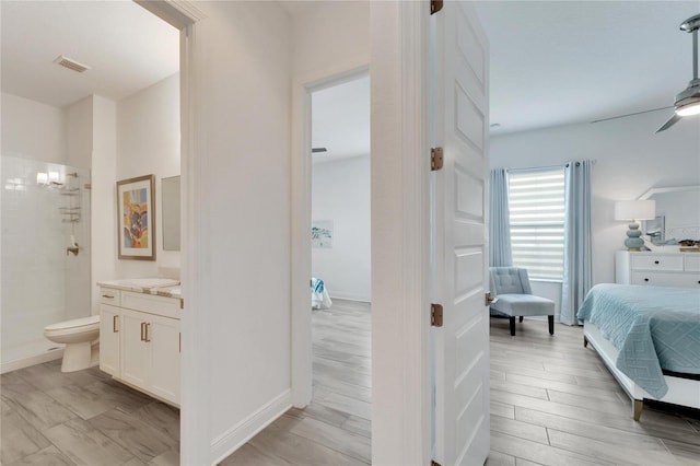 bathroom with toilet, ceiling fan, a shower, and vanity