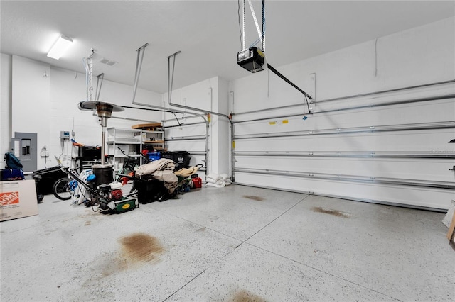 garage with a garage door opener and electric panel