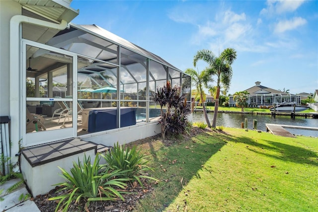 view of yard with glass enclosure and a water view