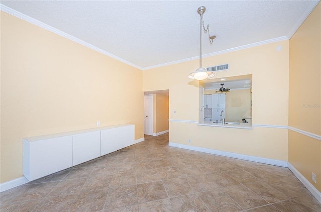 empty room featuring ceiling fan, sink, ornamental molding, and a textured ceiling