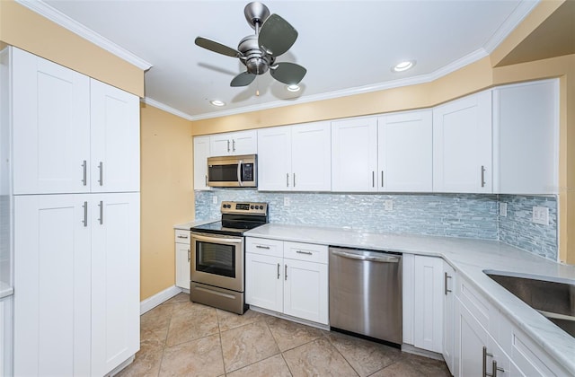 kitchen with decorative backsplash, stainless steel appliances, ceiling fan, crown molding, and white cabinets