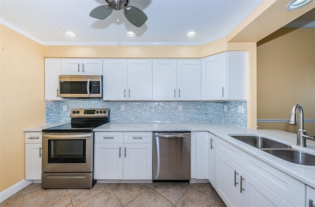 kitchen with decorative backsplash, appliances with stainless steel finishes, crown molding, sink, and white cabinets