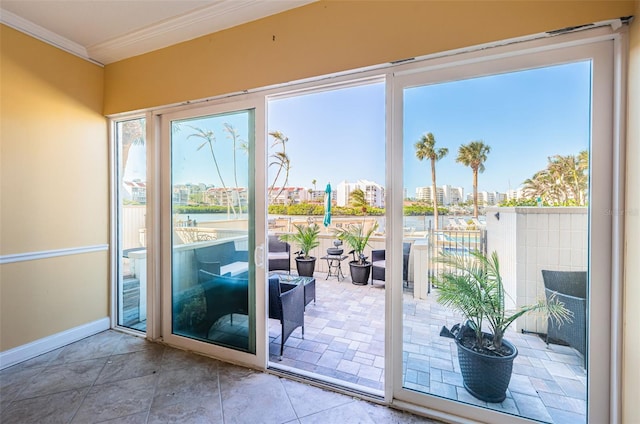 doorway to outside with baseboards, ornamental molding, and a water view