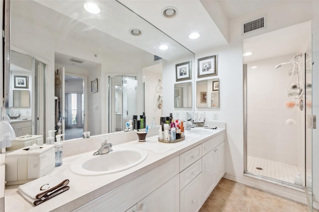 bathroom featuring tile patterned floors, a shower with door, and vanity