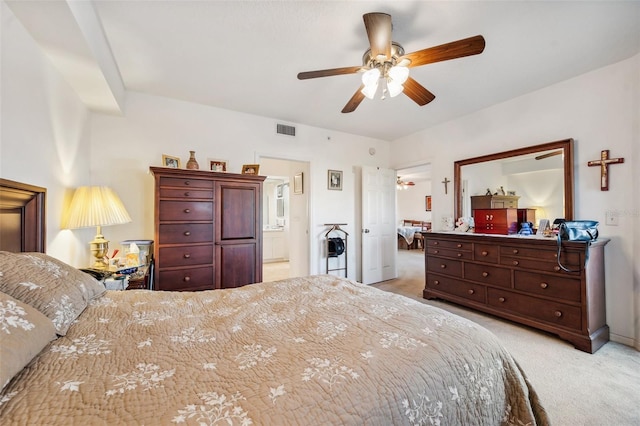 bedroom featuring connected bathroom, light carpet, and ceiling fan