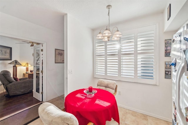 dining area with ceiling fan with notable chandelier