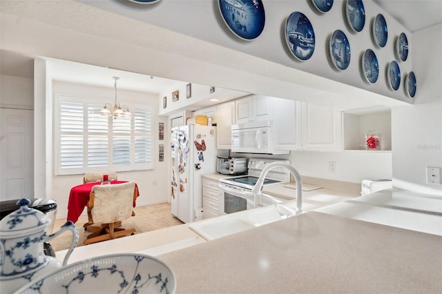 kitchen featuring white cabinetry, a chandelier, pendant lighting, white appliances, and light tile patterned floors