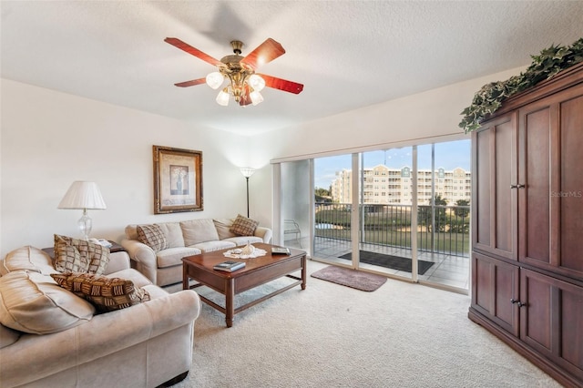 carpeted living room with ceiling fan and a textured ceiling