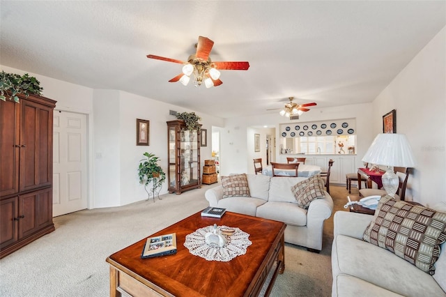 carpeted living room with ceiling fan