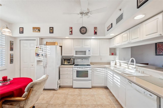 kitchen with white appliances, white cabinetry, and sink