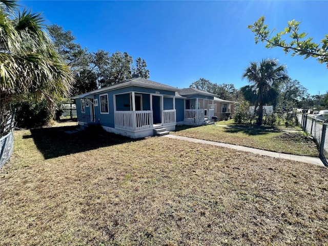 view of front of house with covered porch and a front lawn