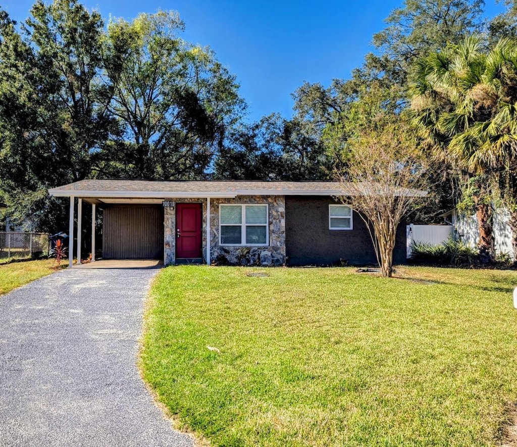 single story home with a front yard and a carport