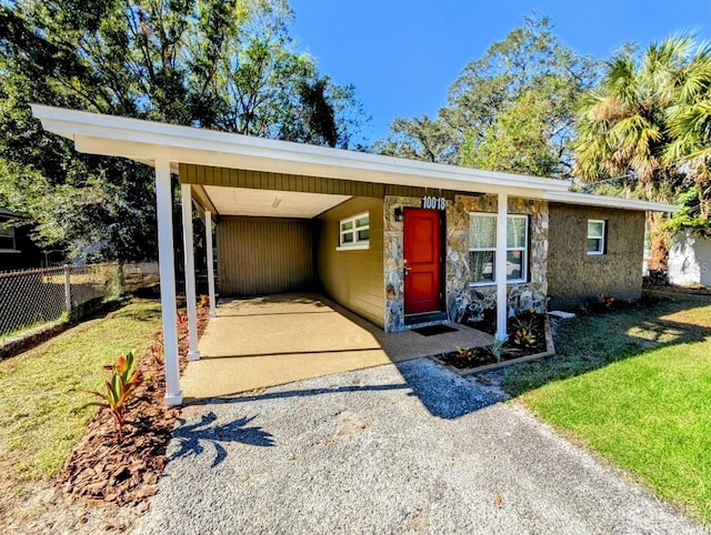 ranch-style house featuring a carport and a front yard