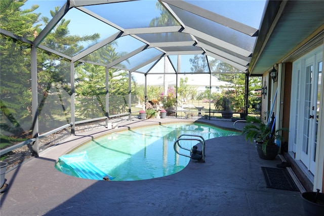 view of swimming pool with glass enclosure and a patio area