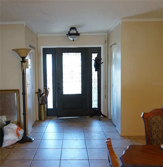 tiled entryway featuring a textured ceiling and crown molding