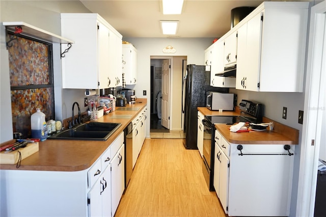 kitchen with black appliances, white cabinetry, and sink