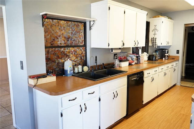 kitchen with white cabinets, black dishwasher, light hardwood / wood-style floors, and sink