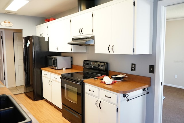 kitchen featuring light wood-type flooring, white cabinetry, and black appliances