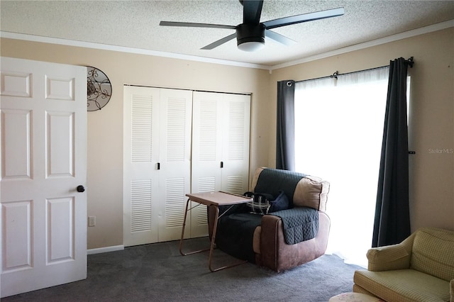 living area featuring ceiling fan, crown molding, dark carpet, and a textured ceiling