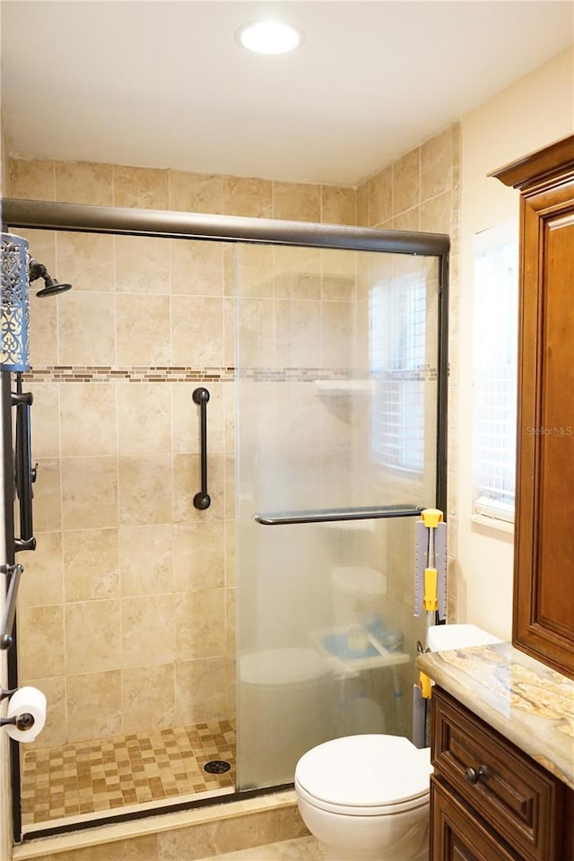 bathroom with vanity, toilet, and an enclosed shower