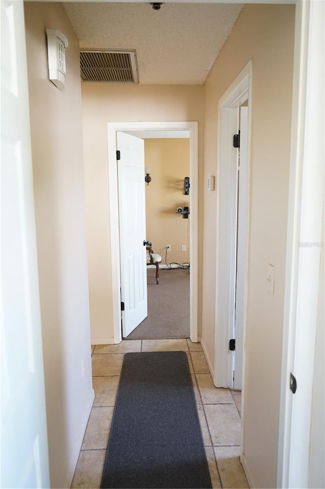 hall with light tile patterned floors