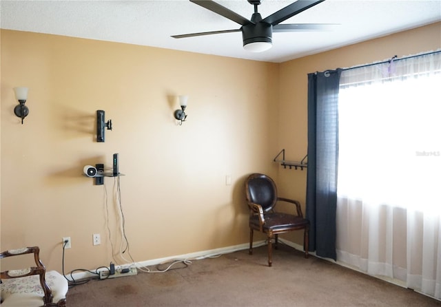 living area with carpet flooring and ceiling fan