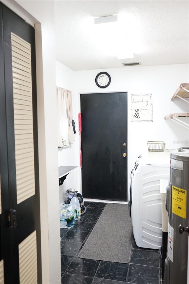 clothes washing area with washer / dryer and electric water heater