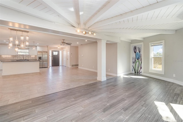 unfurnished living room featuring decorative columns, ceiling fan, beam ceiling, wooden ceiling, and light hardwood / wood-style floors