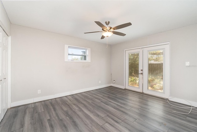 spare room with dark wood-type flooring, a healthy amount of sunlight, and french doors