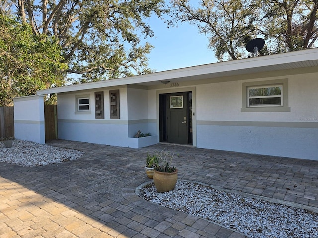 ranch-style home with fence, a patio, and stucco siding