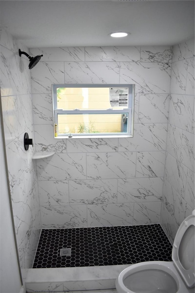 bathroom featuring toilet and tiled shower