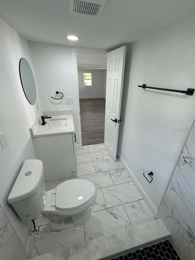 bathroom with hardwood / wood-style floors, vanity, and toilet