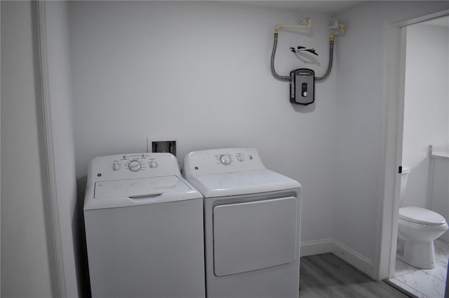 laundry room featuring hardwood / wood-style floors and washing machine and clothes dryer