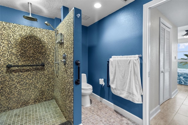 bathroom with tile patterned flooring, ceiling fan, toilet, and tiled shower