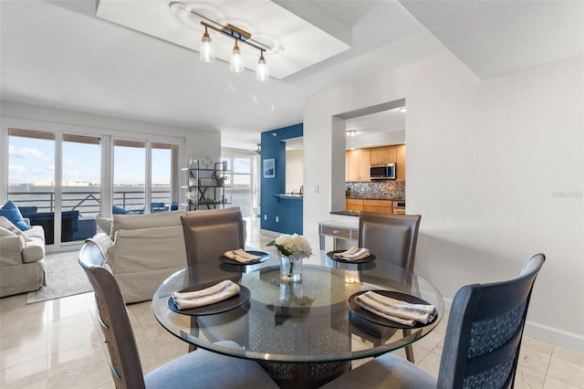 tiled dining room featuring track lighting