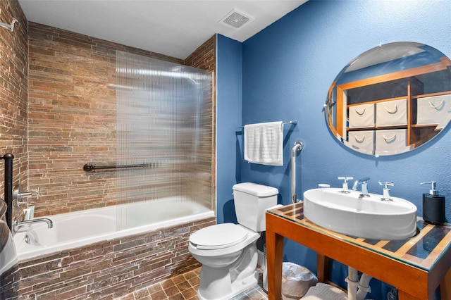 full bathroom featuring tile patterned floors, sink, tiled shower / bath combo, and toilet