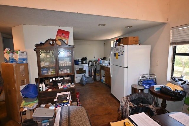 kitchen featuring white refrigerator and concrete flooring