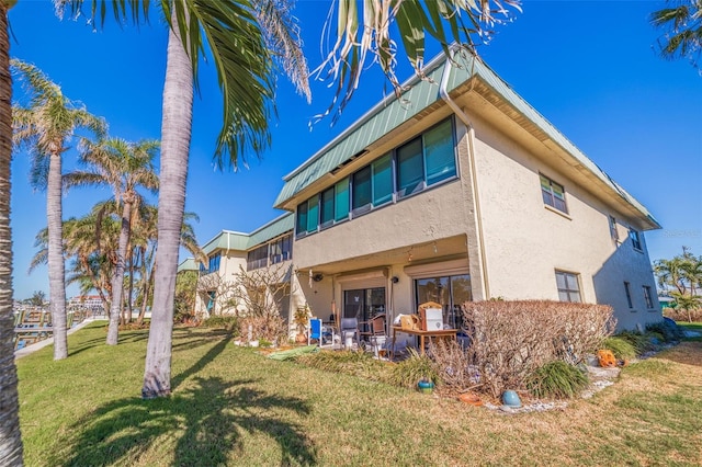 rear view of property featuring a lawn